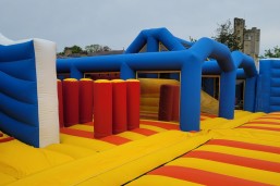 The red, blue and yellow inflatable arena is shown in front of Haggerston Castle, on Haven's Haggerston Castle Holiday Park, Northumberland