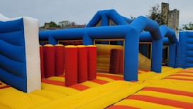The red, blue and yellow inflatable arena is shown in front of Haggerston Castle, on Haven's Haggerston Castle Holiday Park, Northumberland