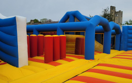 The red, blue and yellow inflatable arena is shown in front of Haggerston Castle, on Haven's Haggerston Castle Holiday Park, Northumberland