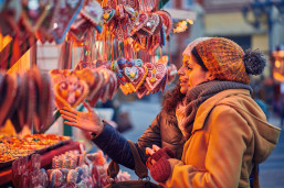 Friends peruse the sweet treats on a Christmas market stall.