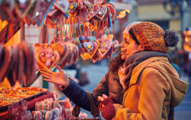 Friends peruse the sweet treats on a Christmas market stall.