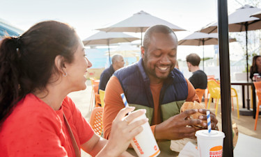 Couple enjoying Burger King food at the outdoor piazza in Skegness Holiday Park