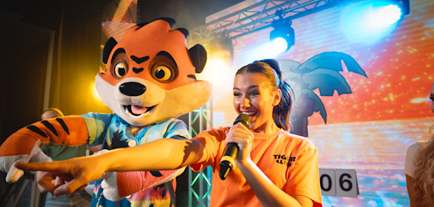 Rory and an entertainment team member on stage for the Tiger Club.