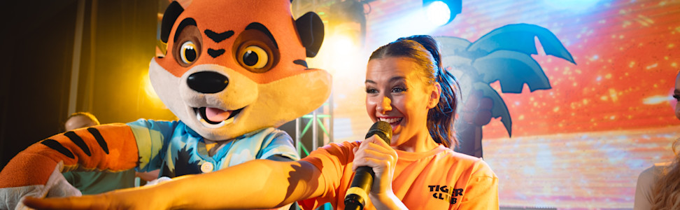 Rory and an entertainment team member on stage for the Tiger Club.