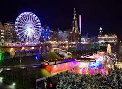 The famous Christmas Market at Edinburgh, Scotland. Night lights lit up setting a lovely scene against the night sky.