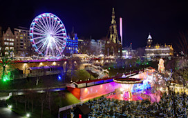 The famous Christmas Market at Edinburgh, Scotland. Night lights lit up setting a lovely scene against the night sky.