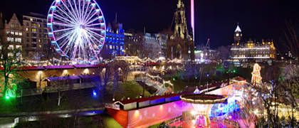 The famous Christmas Market at Edinburgh, Scotland. Night lights lit up setting a lovely scene against the night sky.