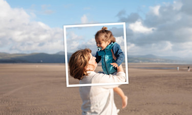 Child is lifted up while enjoying the beach