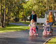 Family walking in park with children on bikes