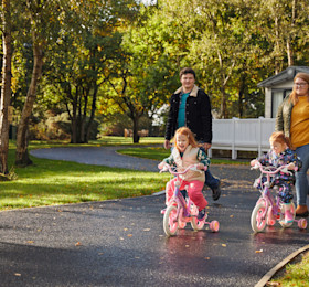 Family walking in park with children on bikes