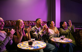 A group of grown-up holidaymakers enjoy the entertainment in a Haven venue.