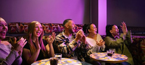 A group of grown-up holidaymakers enjoy the entertainment in a Haven venue.