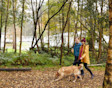 Couple walking with a dog in a forest