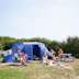 A family relax by their tent at Seaview in Dorset.