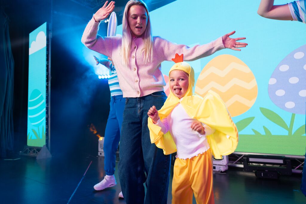 a mum and child on stage with the child dressed up as a chicken