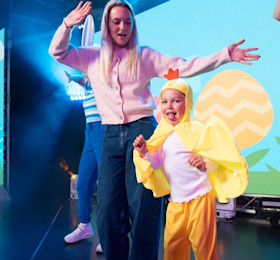 a mum and child on stage with the child dressed up as a chicken