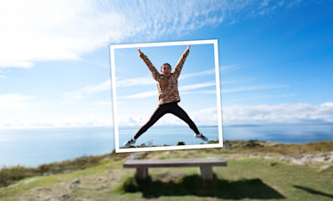 Mum doing a star jump during a walk while posing for a photo
