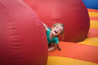 A young girl laughs among the obstacles on the inflatable arena.
