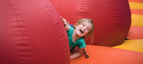 A young girl laughs among the obstacles on the inflatable arena.