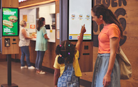 Family selecting their order on the screens at Burger King®