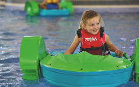 A young girl tries out the Aqua Paddlers activity in a pool at Haven