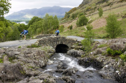 Cyclists crossing Ashness Bridge in the Lake District.