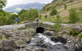 Cyclists crossing Ashness Bridge in the Lake District.