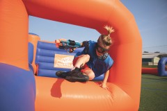 A guest jumping over the inflatables playing Nerf Training Camp