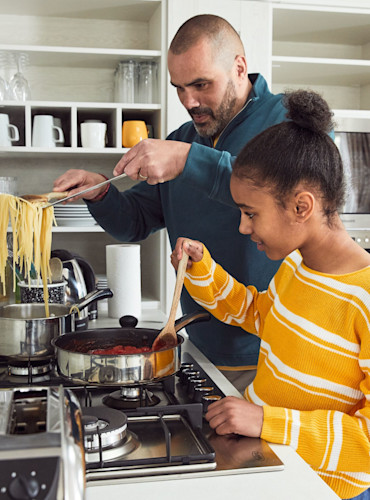 Family cooking on the gas hob in a caravan