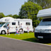 A family walks past their campervan at Kiln Park, South Wales.
