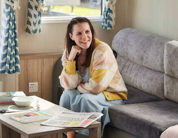 Mum sat on the sofa of her caravan holiday home
