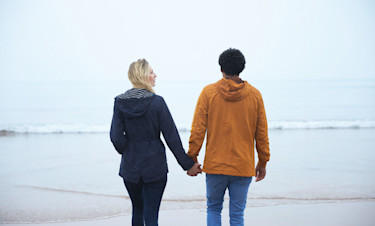 A couple stroll hand-in-hand along the beach at Devon Cliffs.