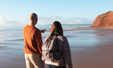 A couple stroll hand-in-hand along the beach at Devon Cliffs.