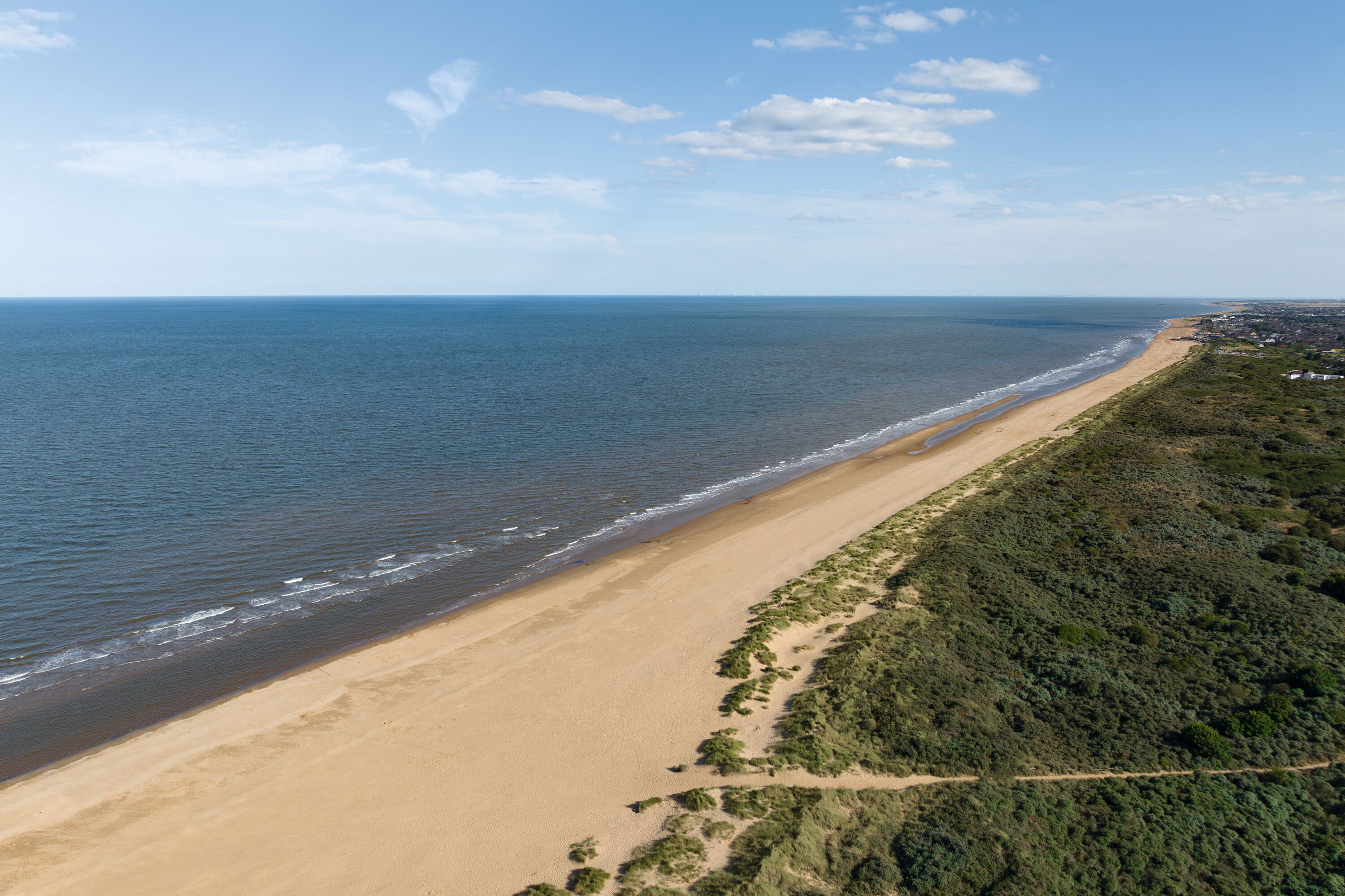 A girl jumps on the sandy beach in her wellies near Haven Golden Sands, Mablethorpe.