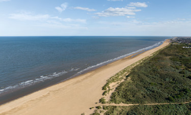 A girl jumps on the sandy beach in her wellies near Haven Golden Sands, Mablethorpe.