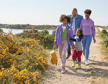 A family enjoy a nature walk at Church Farm Holiday Park, Sussex.