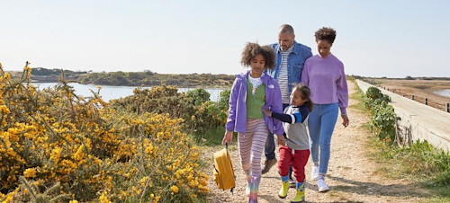 A family enjoy a nature walk at Church Farm Holiday Park, Sussex.