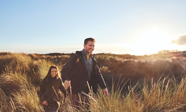 Couple walking in the dunes opposite Golden Sands