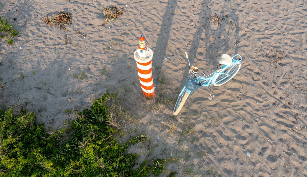 Overheard view of a bicycle parked on the beach sand
