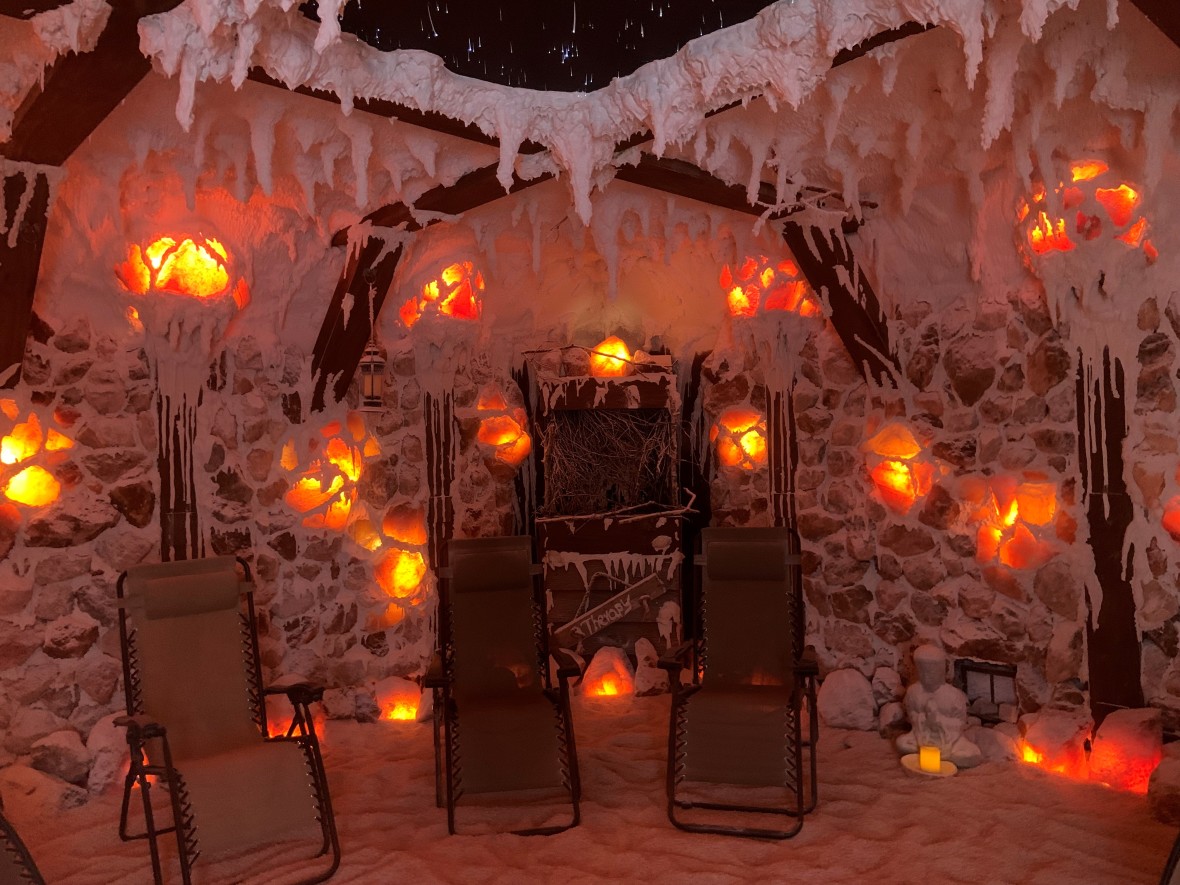 Interior of Salt Cave illuminated with glowing orange lights and chairs set up for relaxation