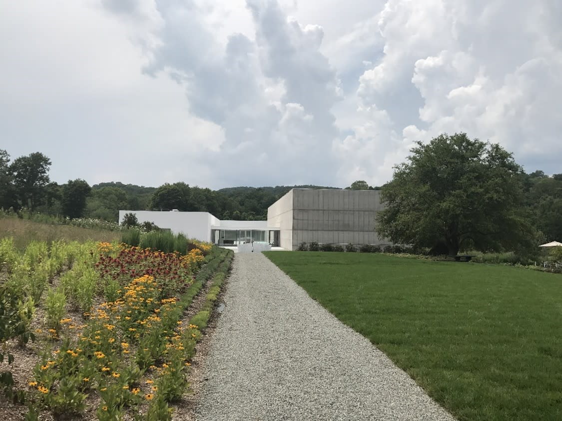 Exterior of Magazzino Italian Art, a gray modern building sitting surrounded green grass and trees