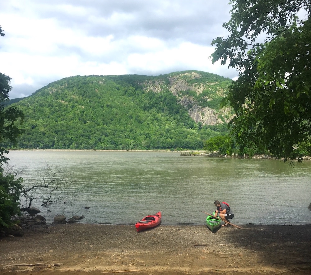 A kayaker on the shore of the Hudson River in Cold Spring