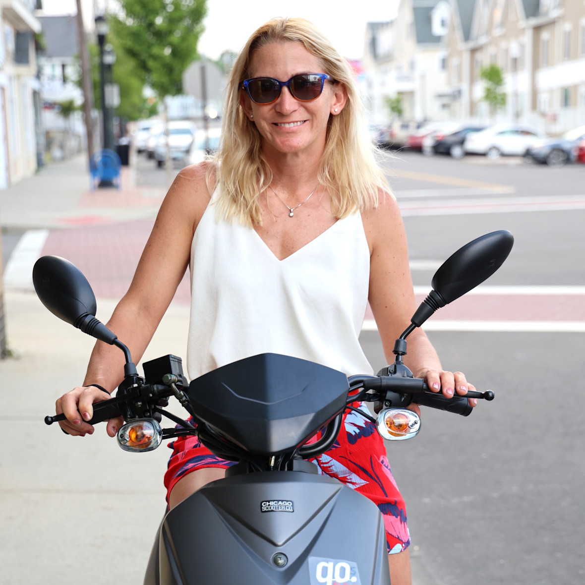 Smiling woman on scooter from Scoot & Paddle
