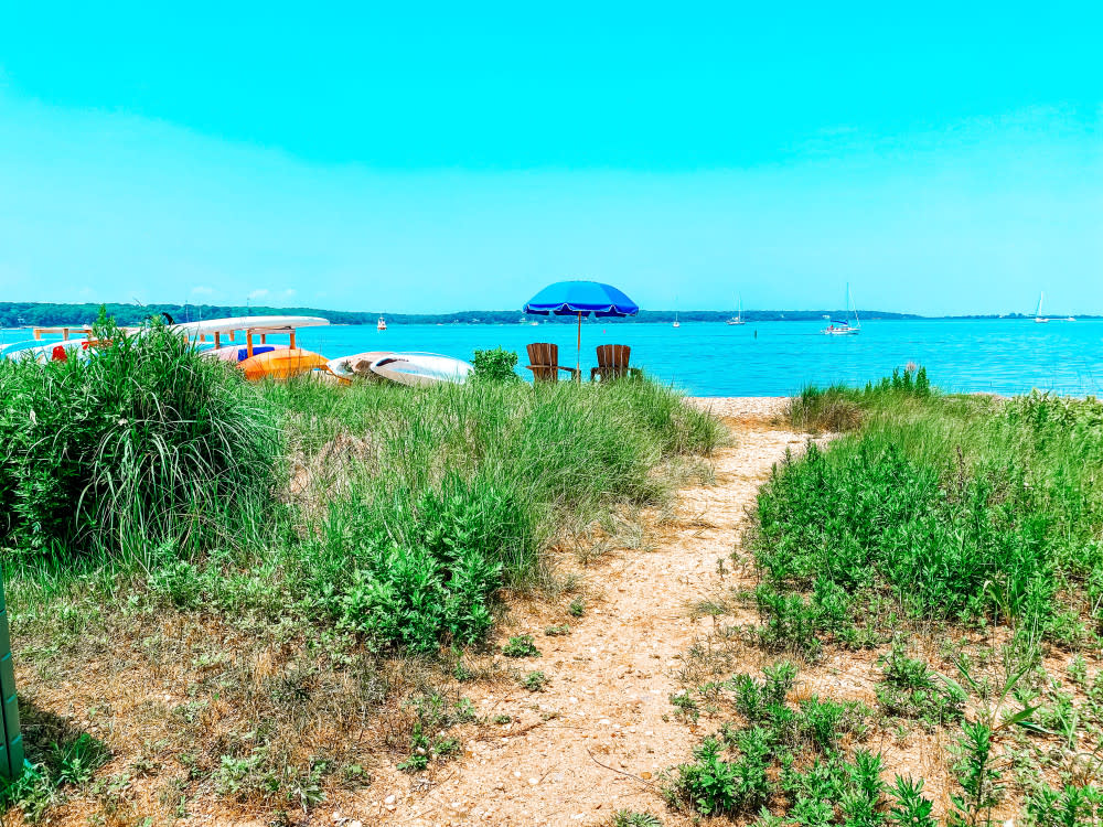 A beach path leading to the kayaks of Paddle Diva