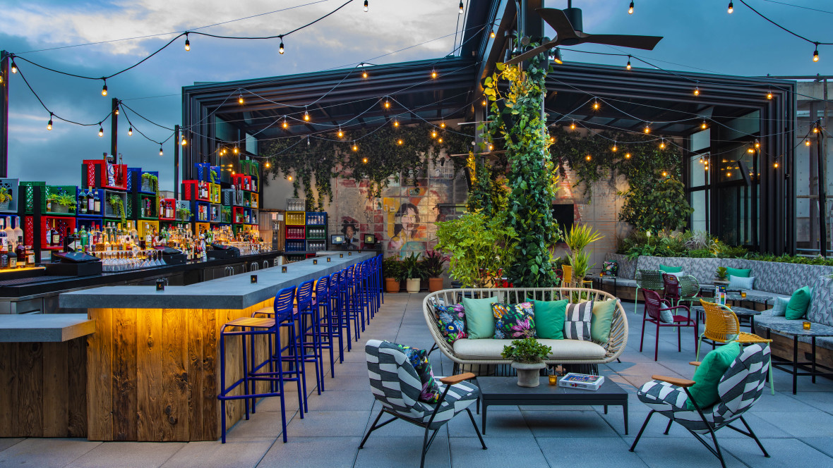 Brightly colored decor and lush vegetation fill The Ready Roof's open-air space