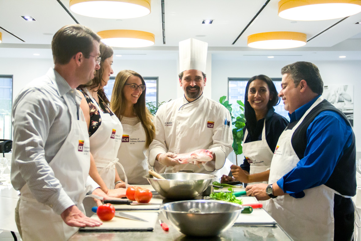 A group of Institute of Culinary Education students surrounding their chef instructor