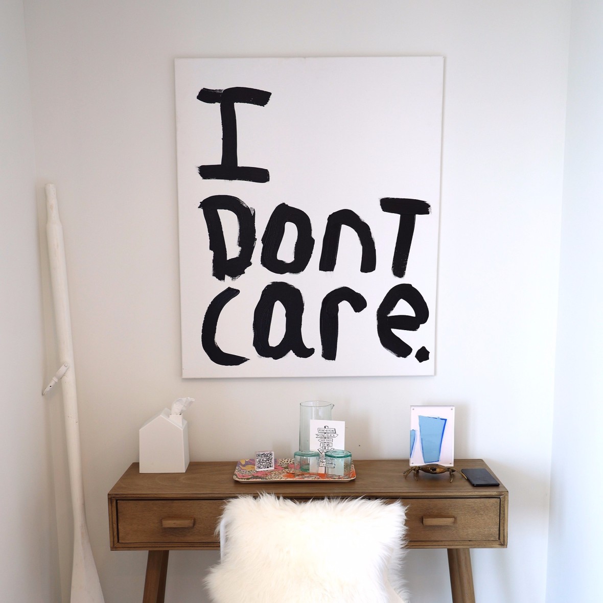 Desk with large 'I don't care' mounted print on wall
