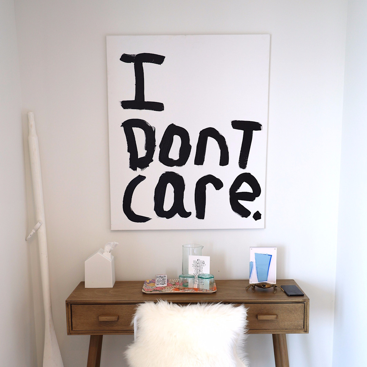 Desk with large 'I don't care' mounted print on wall