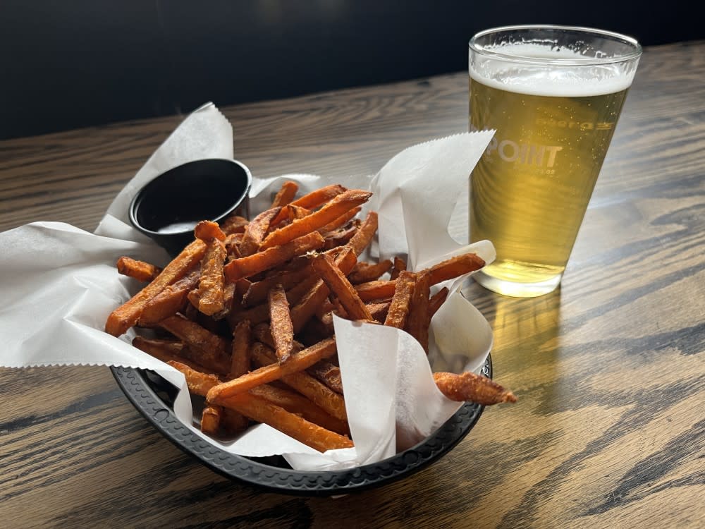 A generous serving of sweet potato fries alongside a cold beer at Croxleys
