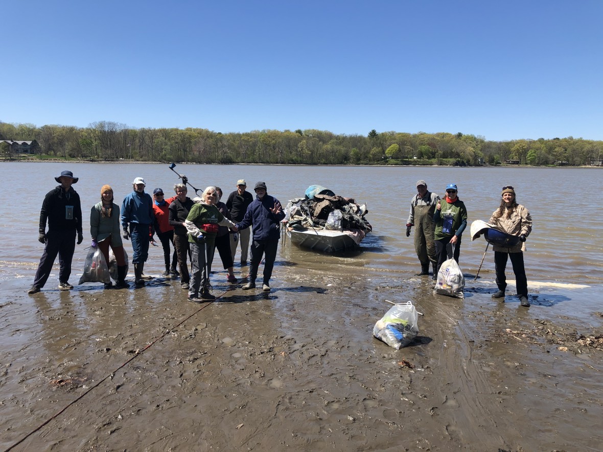 Group of Riverkeeper volunteers standing in shallow water of Hudson River after cleaning up debris